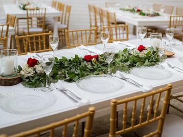 Mesa elegante decorada con flores y copas para evento.