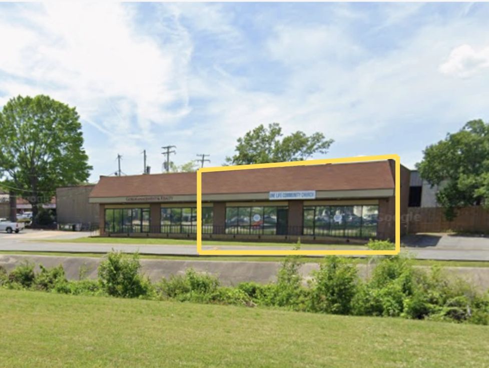 A small commercial building with a sign for "One Life Community Church."