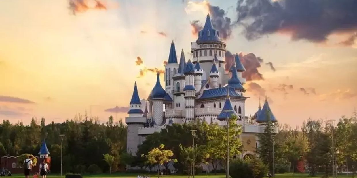 A fairytale castle with blue spires at sunset.