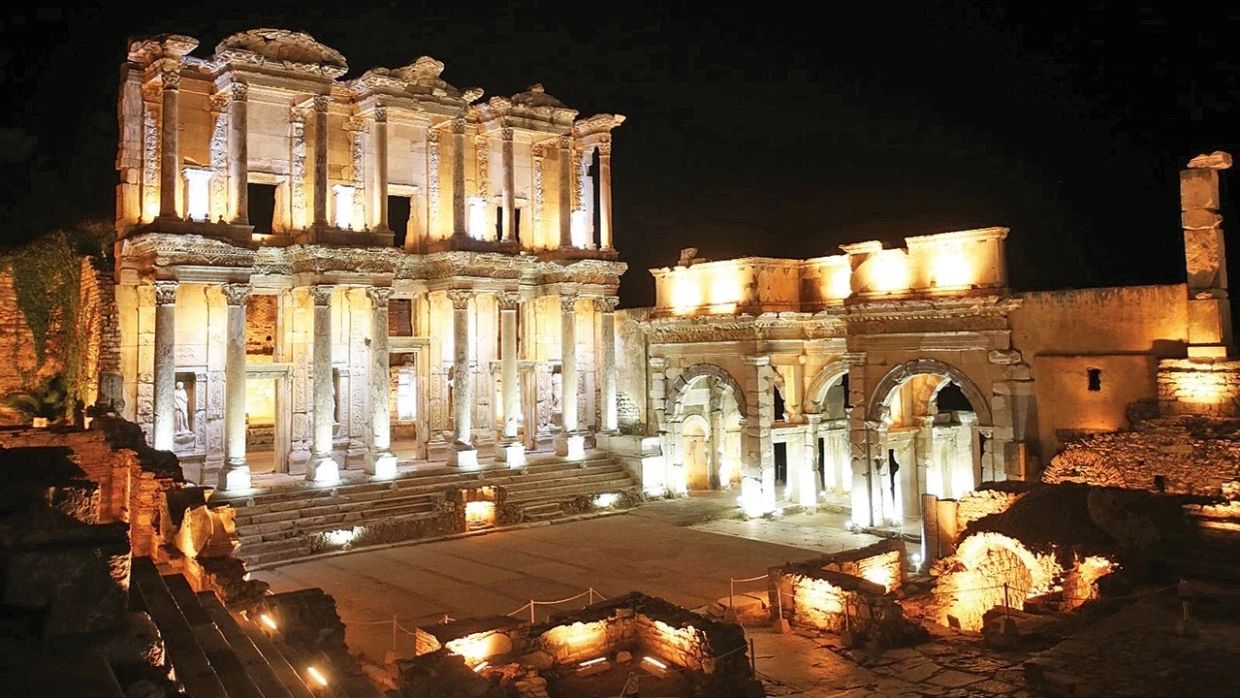 Gece ışıklarıyla aydınlatılmış antik yapı.