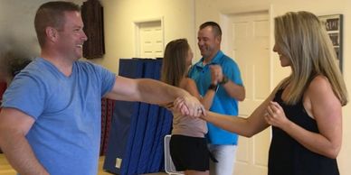 two couples share a ballroom dancing lesson with Ganine-dancers look and smile at their partners