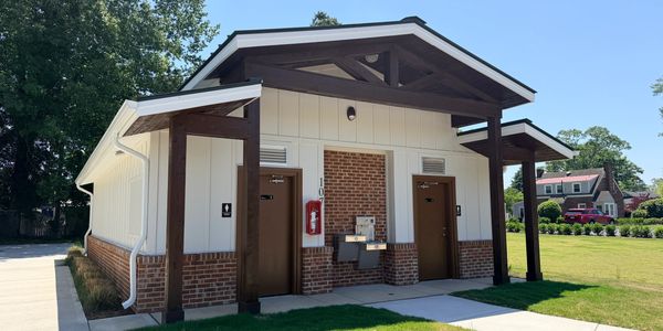 Public restroom building with separate men's and women's entrances in a park.