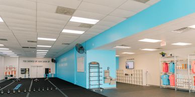 Interior of a modern gym with blue walls and workout equipment.
