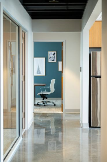 Modern office corridor with a white swivel chair.