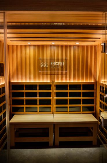 Interior of a warm, wooden sauna room with benches and subtle lighting.
