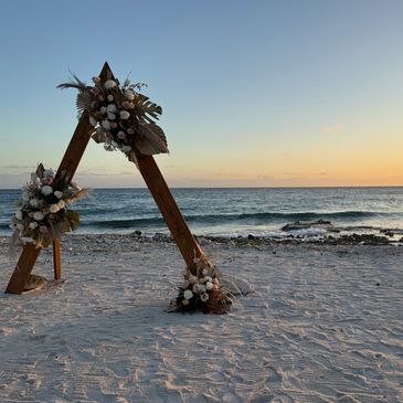 Beachside wedding arch at sunset.