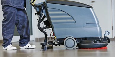 man using an auto scrubber to clean a floor