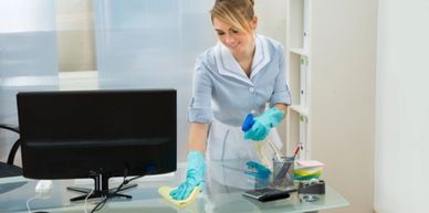 woman dusting an office desk