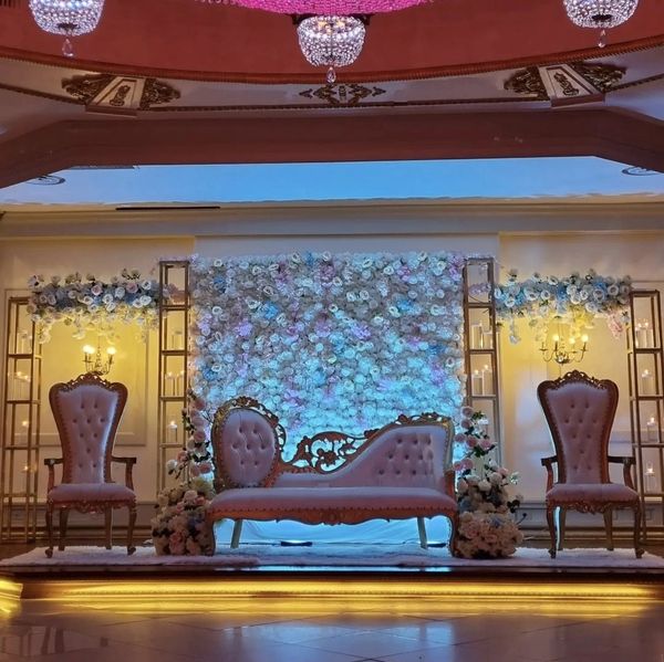 Elegant wedding stage with floral backdrop and vintage seating.