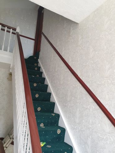green carpet on stairs and wall paper on the walls