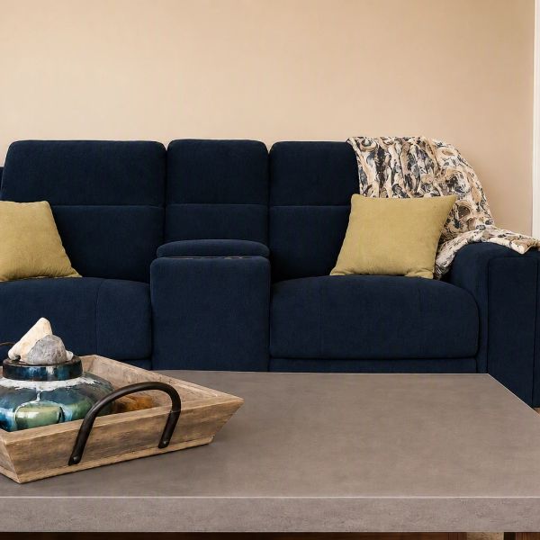 Modern navy blue sofa with yellow cushions and a decorative throw.