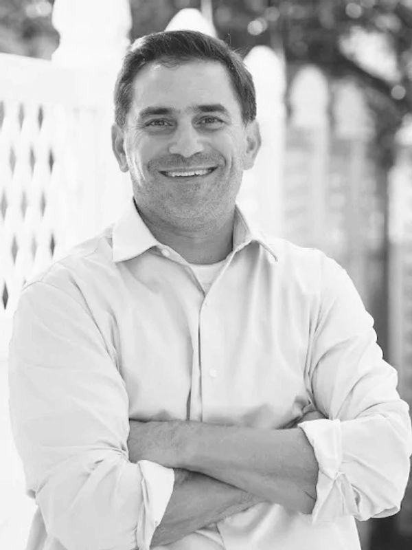 Smiling man in casual rolled-up sleeves shirt.