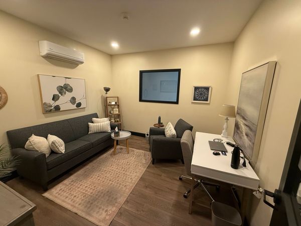 Cozy living room with sofa, chair, and desk.