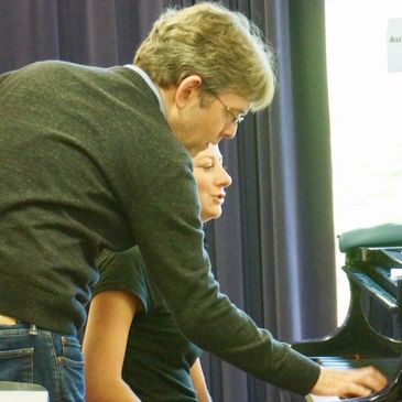 Eugene Asti coaching a student at a piano