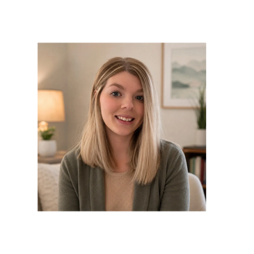 Smiling young woman with blonde hair in cozy indoor setting.