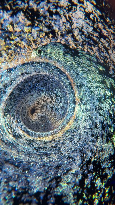 Close-up of a swirling, glittery vortex with rainbow reflections.