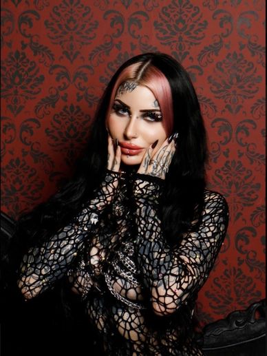 Woman with black and pink hair in gothic lace outfit.