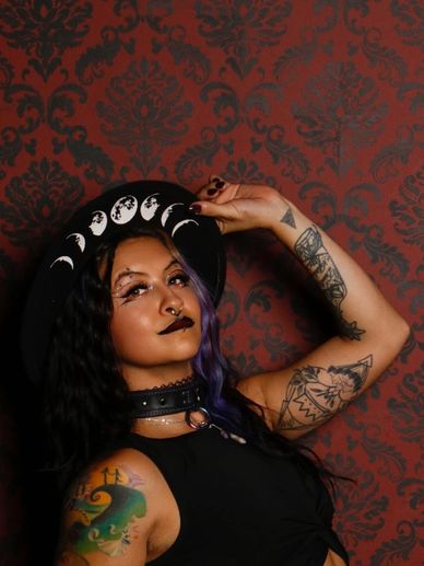 Woman with tattoos and a moon phase hat.