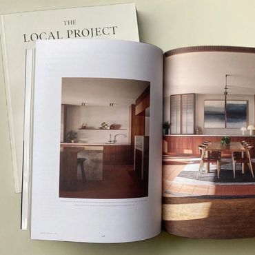 Open magazine showing stylish interior design with wooden furniture and warm lighting.