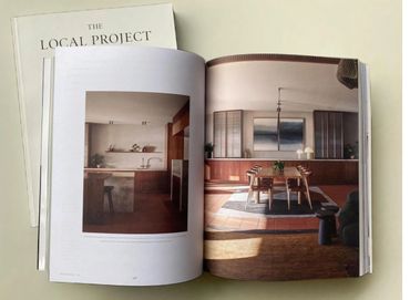 Open magazine showing stylish interior design with wooden furniture and warm lighting.