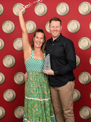 Couple celebrating with an award at a Local Business Awards event.