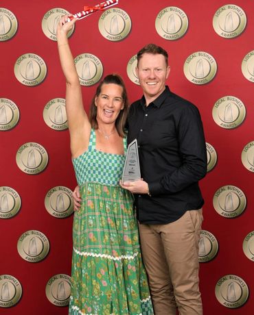 Couple celebrating with an award at a Local Business Awards event.