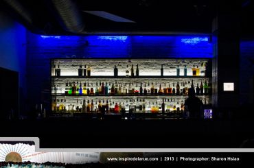 Backlit bar shelves with bottles and blue neon lighting.