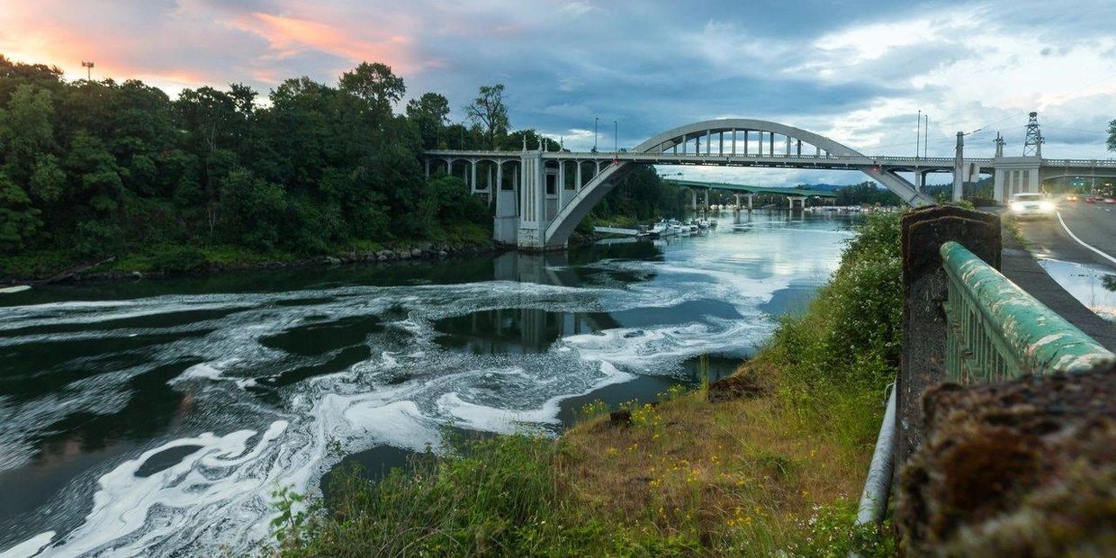 View of a bridge over a river during sunset.