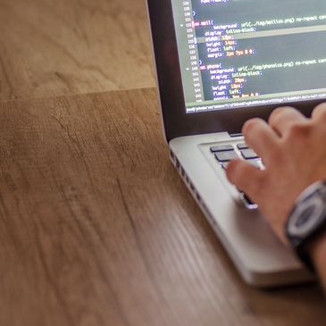 man writing code on a laptop