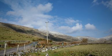 Light snow on mountain. Stone walls,blue sky on Conor Pass Road.