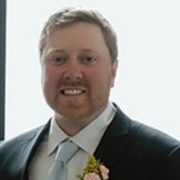 Man in a suit smiling.