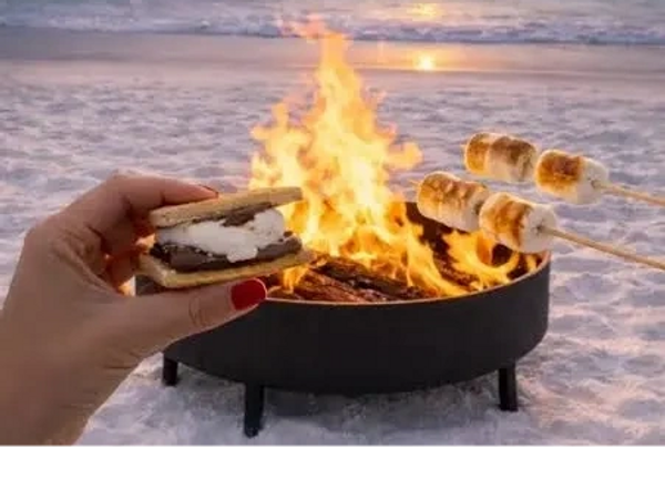 Making s'mores and roasting marshmallows on a beach bonfire at sunset.