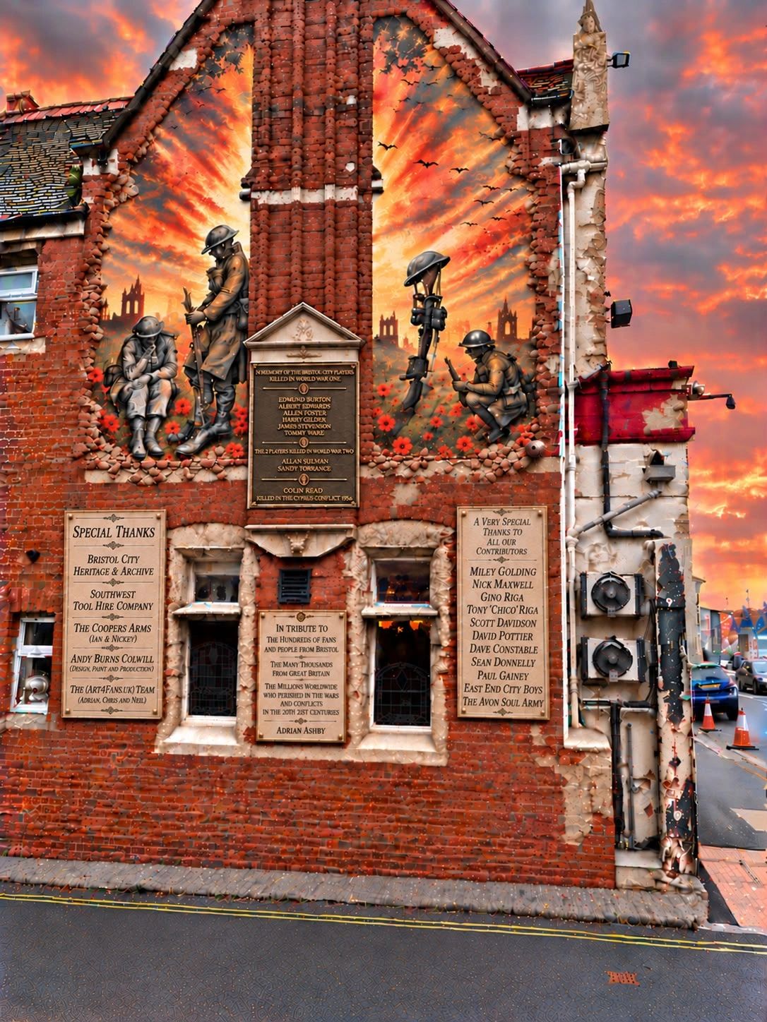 War memorial mural on a brick building at sunset.