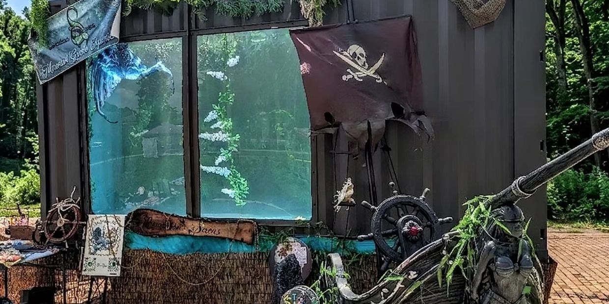 Pirate-themed outdoor decoration with a skull flag and ship wheel.
