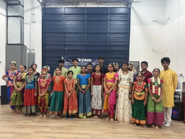 A group of people in traditional Indian attire posing indoors.