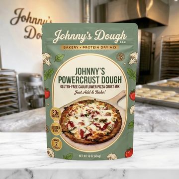 Johnny's PowerCrust Dough gluten-free pizza mix displayed on a bakery counter.