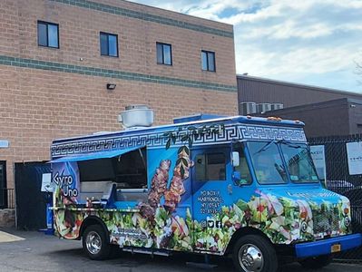 Colorful food truck parked near a brick building.