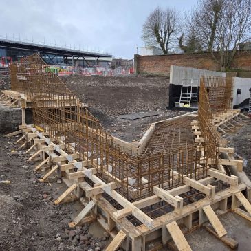 Construction site with concrete foundation and metal rebar framework.