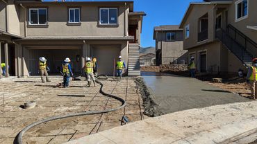 Workers pouring a concrete driveway.