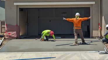 Men finishing a concrete driveway.