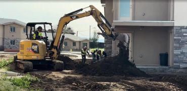 Men moving dirt with an excavator. 