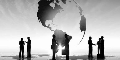 Businesspeople silhouettes with a globe backdrop.