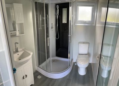 Ready-to-go bathroom with toilet, shower, vanity sink, medicine cabinet and mirror.