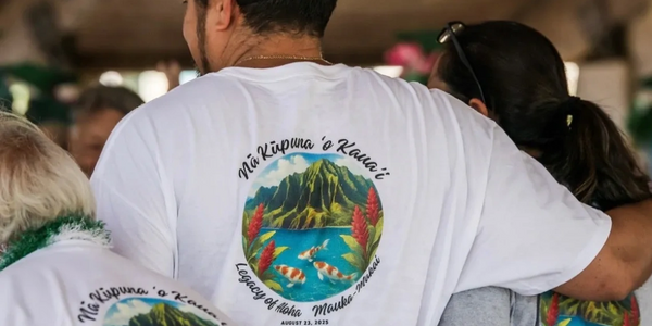 People wearing white shirts with a colorful Hawaiian design on the back.