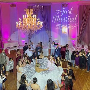 Bride dancing joyfully surrounded by guests at a wedding reception.