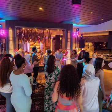 People socializing and dancing at a lively indoor party with colorful lights.