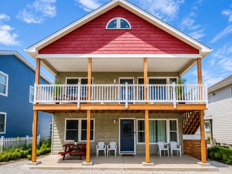 Bright house with red roof and wooden pillars.