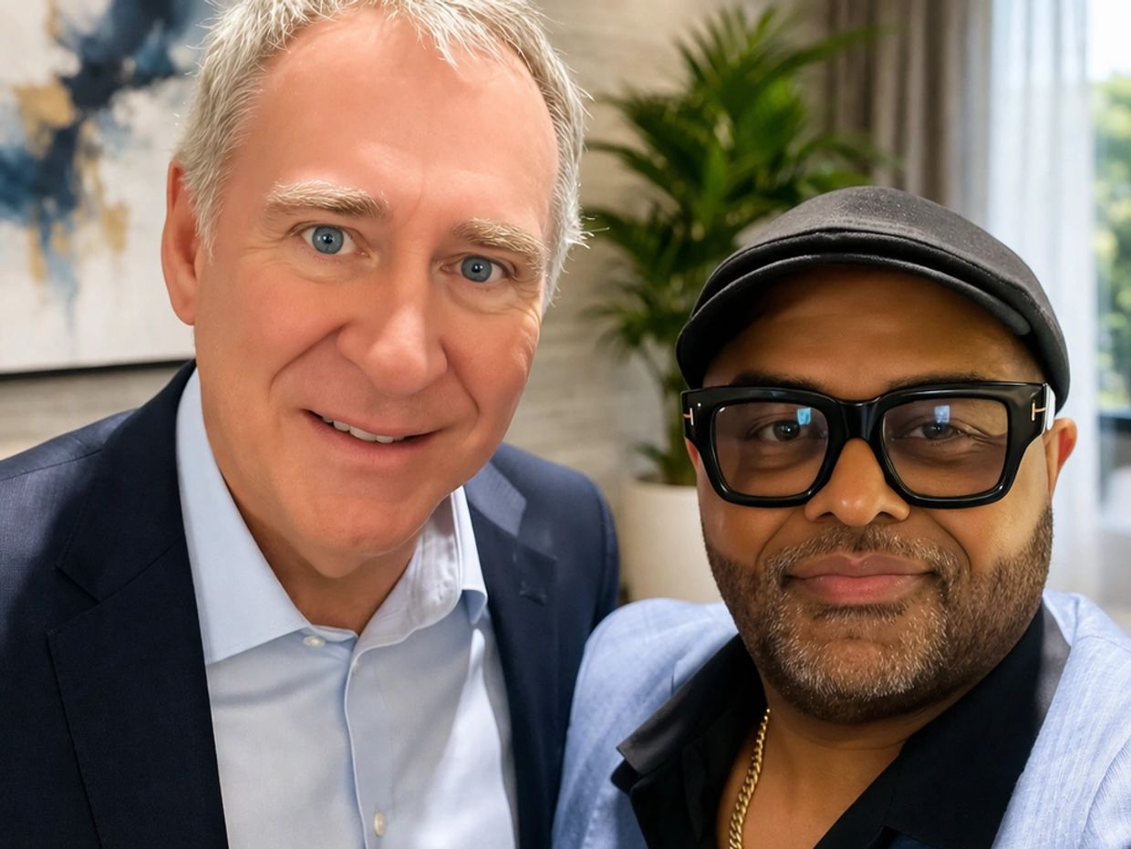 Two men posing closely for a selfie indoors, dressed in suits.