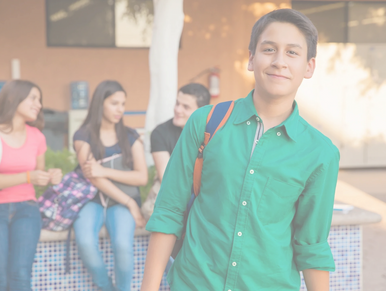 adolescent heureux à l'école avec son sac à dos sur une épaule