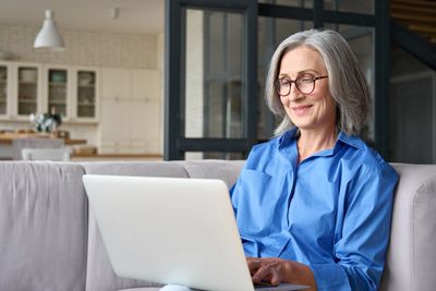Ohio woman smiling at laptop, representing hope and healing after grief and loss counseling.